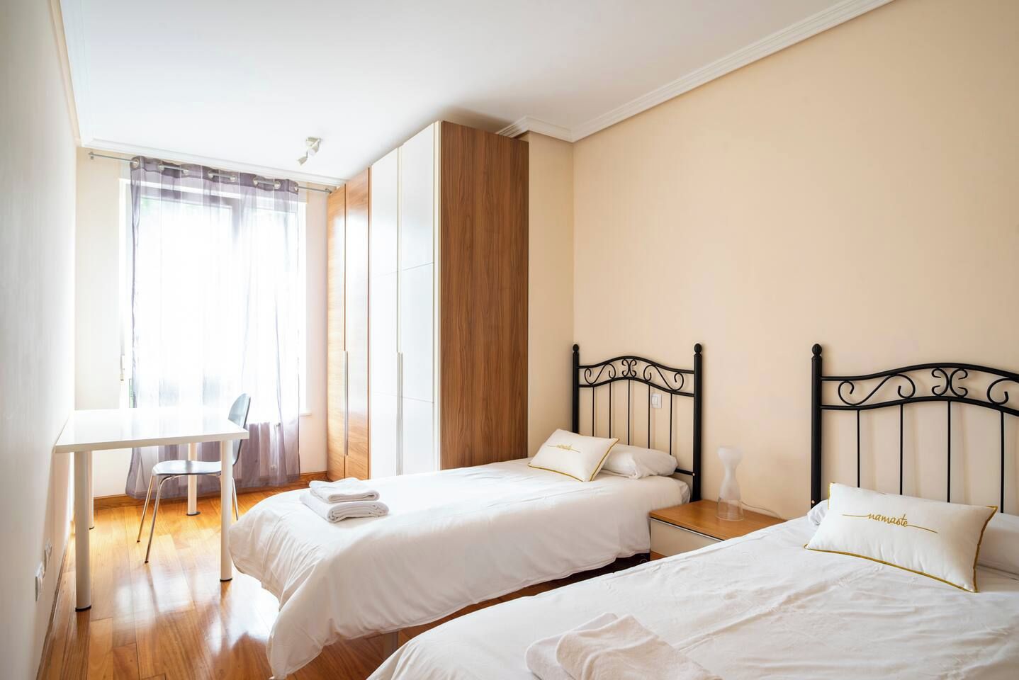 Une chambre avec deux lits, un bureau et une chaise.