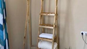 Eine Holzleiterregal-Einheit an einer Wand, in der Nähe eine Steckdose.