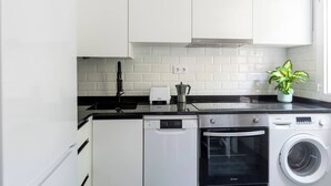 Een moderne keuken met witte kasten, een Bosch vaatwasser, een Bosch oven en een wasmachine.