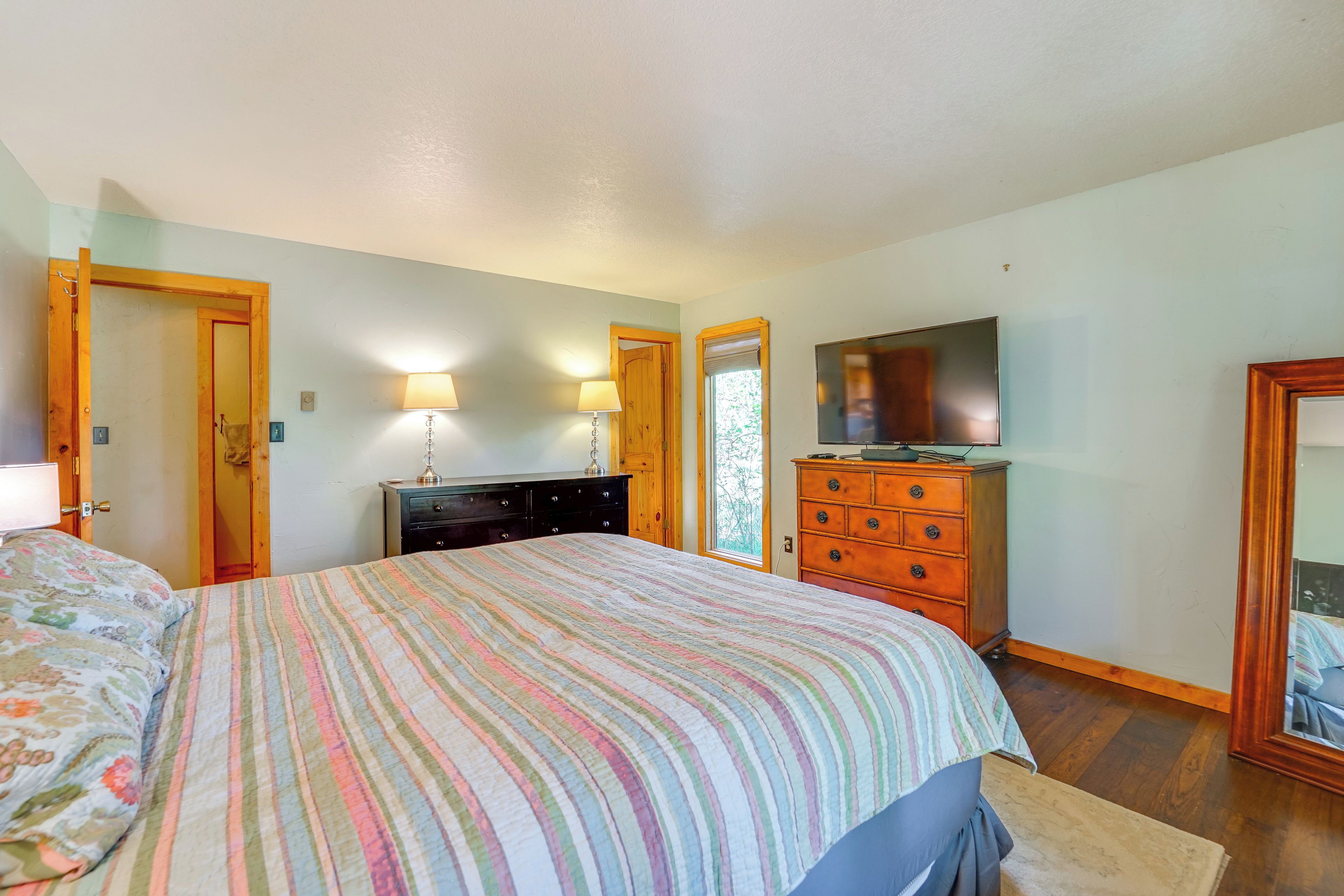 Ein Schlafzimmer mit Bett, Kommode und Fernseher.