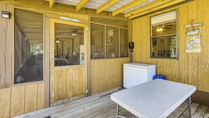 Een houten chalet met een eettafel, een koelkast en een raam met een bordje.