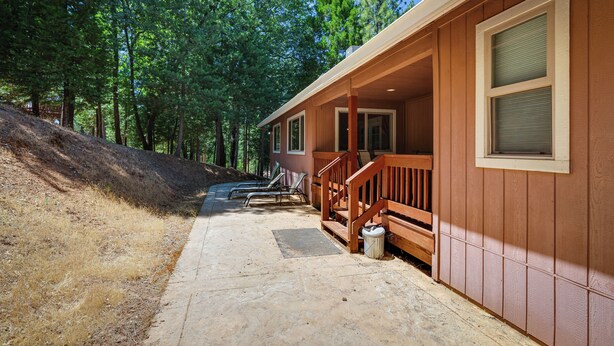 A cabin with a covered porch, a wooden staircase, and a view of the surrounding forest. - Groveland Vacation Rental Near Pine Mountain Lake! (Groveland)