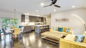 A modern kitchen with dark wood cabinets, stainless steel appliances, and a central island with bar stools. - Stylish & Modern Lenexa Haven w/ Fire Pit & Deck! (Lenexa)