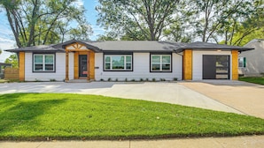 A single-story house with a front entrance, a garage, and a driveway. - Stylish & Modern Lenexa Haven w/ Fire Pit & Deck! (Lenexa)
