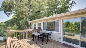 Une terrasse avec une table et des chaises, donnant sur un lac.