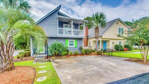A two-story house with a balcony, a front yard with stepping stones, and a palm tree. - North Myrtle Beach Home 2 Blocks to Ocean! (North Myrtle Beach)