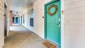 A corridor with a teal door, a doormat, and a brick wall. - Quiet Condo w/ Patio: 3 Mi to Dtwn Branson! (Branson)