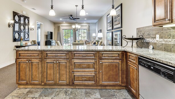 A spacious kitchen with a large island, wooden cabinets, and a dishwasher. - Quiet Condo w/ Patio: 3 Mi to Dtwn Branson! (Branson)