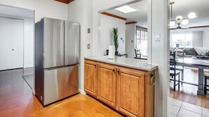 Una cocina con armarios de madera, un refrigerador de acero inoxidable y una encimera.