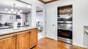Una cocina con armarios de madera, horno de acero inoxidable y encimera con dispensador de toallas de papel.