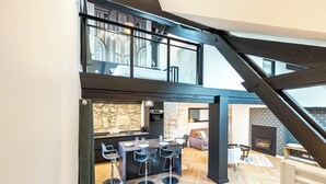 A modern loft with a kitchen, dining area, and a fireplace. - Matterhorn (Annecy)