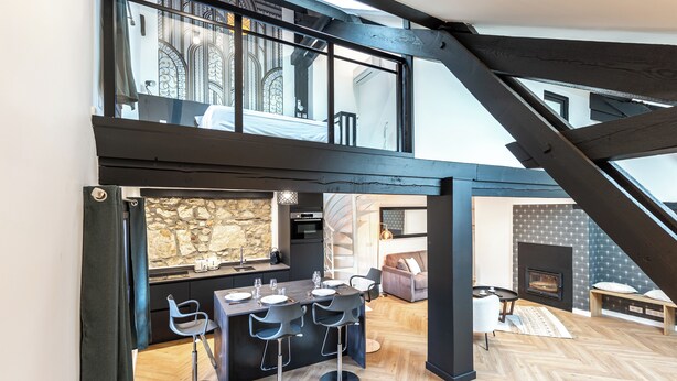 A modern loft with a dining area, kitchen, and a fireplace. - Matterhorn (Annecy)