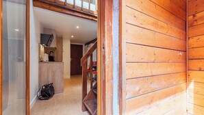 Un intérieur en bois avec un escalier menant à une chambre à coucher située en mezzanine.