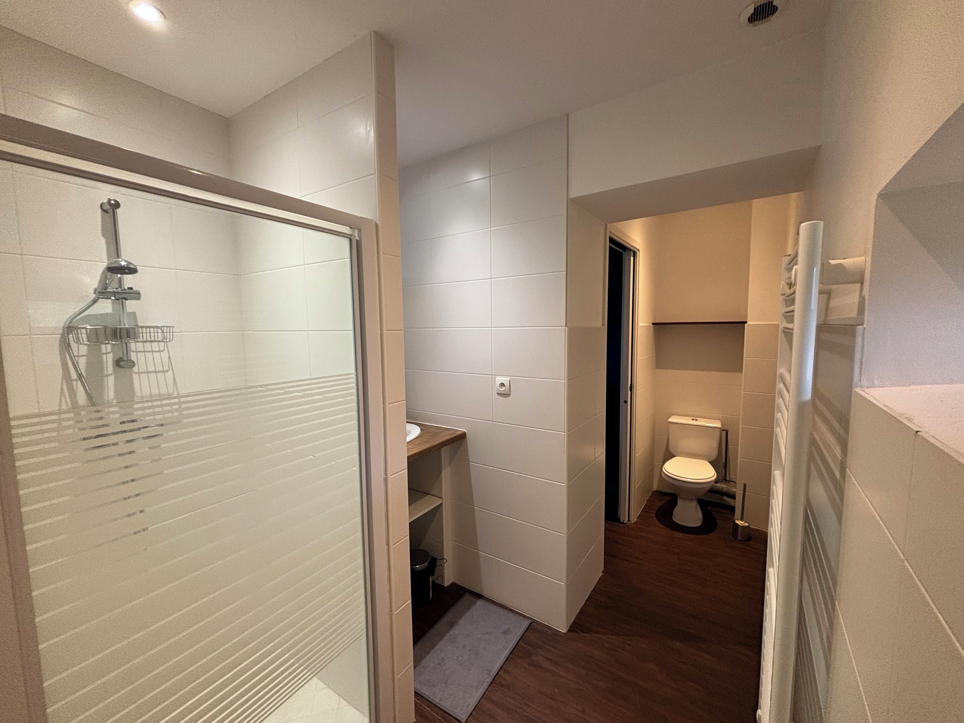 Een douche, handdoeken, zeep, toiletpapier