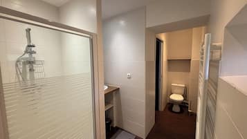 Een douche, handdoeken, zeep, toiletpapier