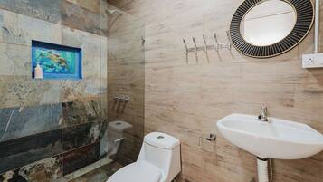 A bathroom with a toilet, sink, and shower. There is a framed picture on the wall and a mirror above the sink.