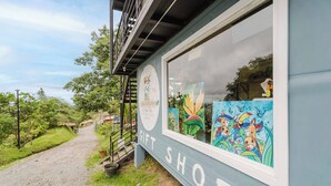 A gift shop with a signboard and artwork on display. - Ronny's Flat Manuel Antonio (Quepos)