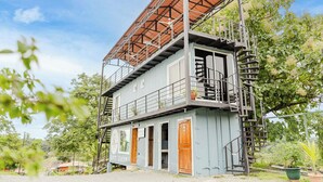 A two-story building with a metal staircase and a wooden door. - Ronny's Flat Manuel Antonio (Quepos)