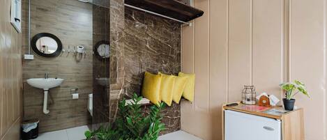 A bathroom with a sink, mirror, towel rack, and a small refrigerator.