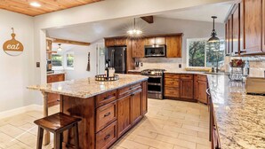 Una cocina amplia con armarios de madera, encimeras de granito y una isla grande.