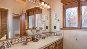 Un baño con dos lavamanos, un espejo grande y una ventana.