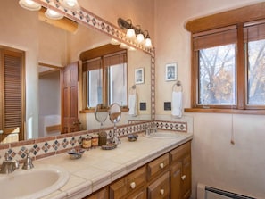 Un bagno con due lavandini, uno specchio grande e una finestra.