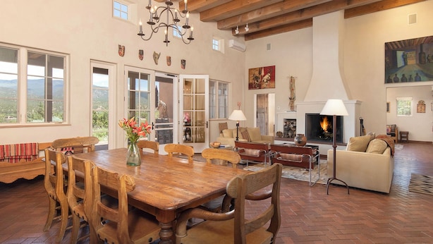 Un vaste espace de vie doté d’une cheminée, de meubles en bois et d’une table à manger.
