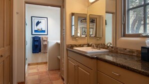Baño con lavamanos, espejos y ventana.