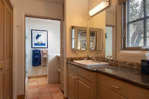 Un bagno con lavandino, specchi e una finestra.