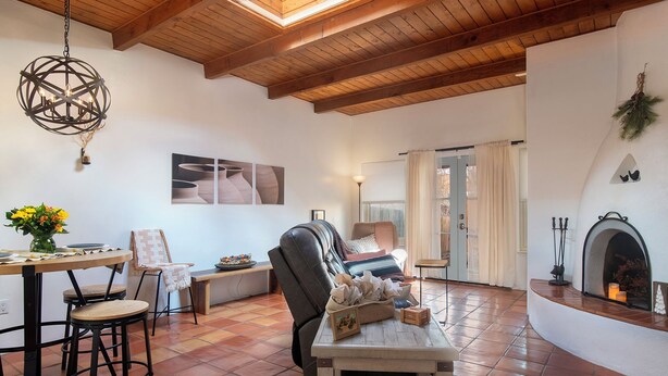 Uma sala de estar espaçosa com lareira, uma mesa de jantar com cadeiras e um espaço de estar acolhedor.