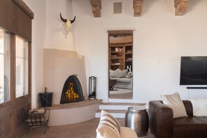 A living room with a fireplace, a television, and a bookshelf.
