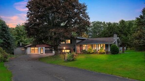 Une maison à deux étages avec une allée menant à la porte d’entrée.
