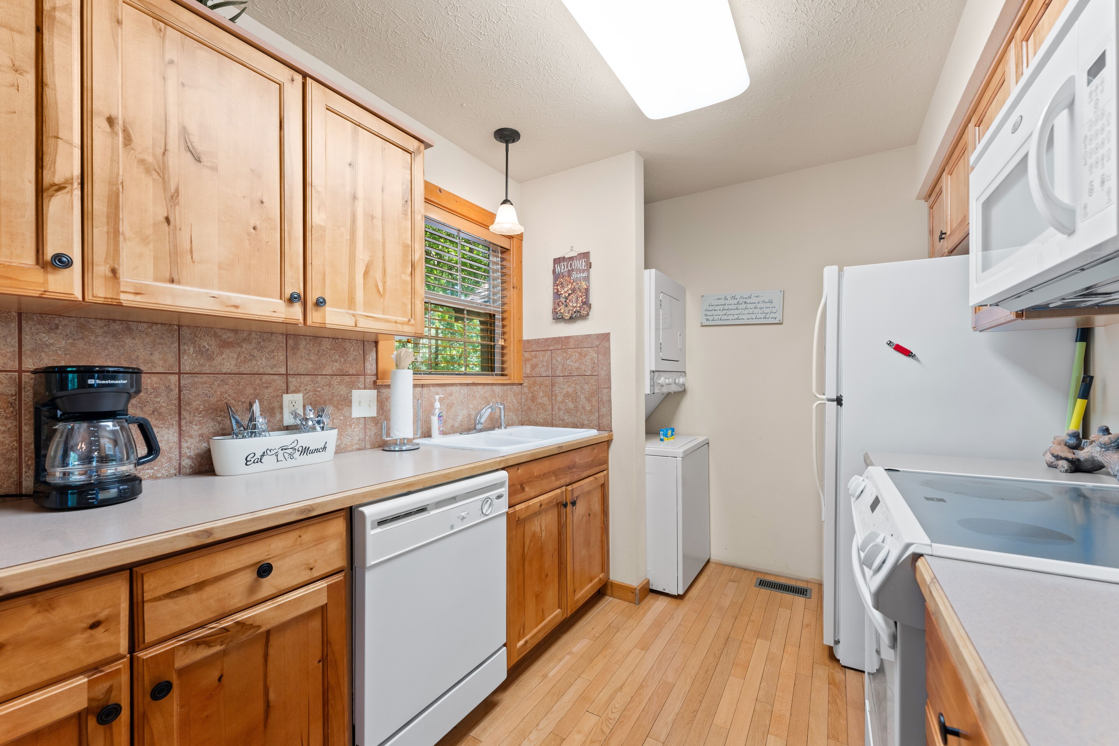 A kitchen with wooden cabinets, a dishwasher, a refrigerator, and a microwave.