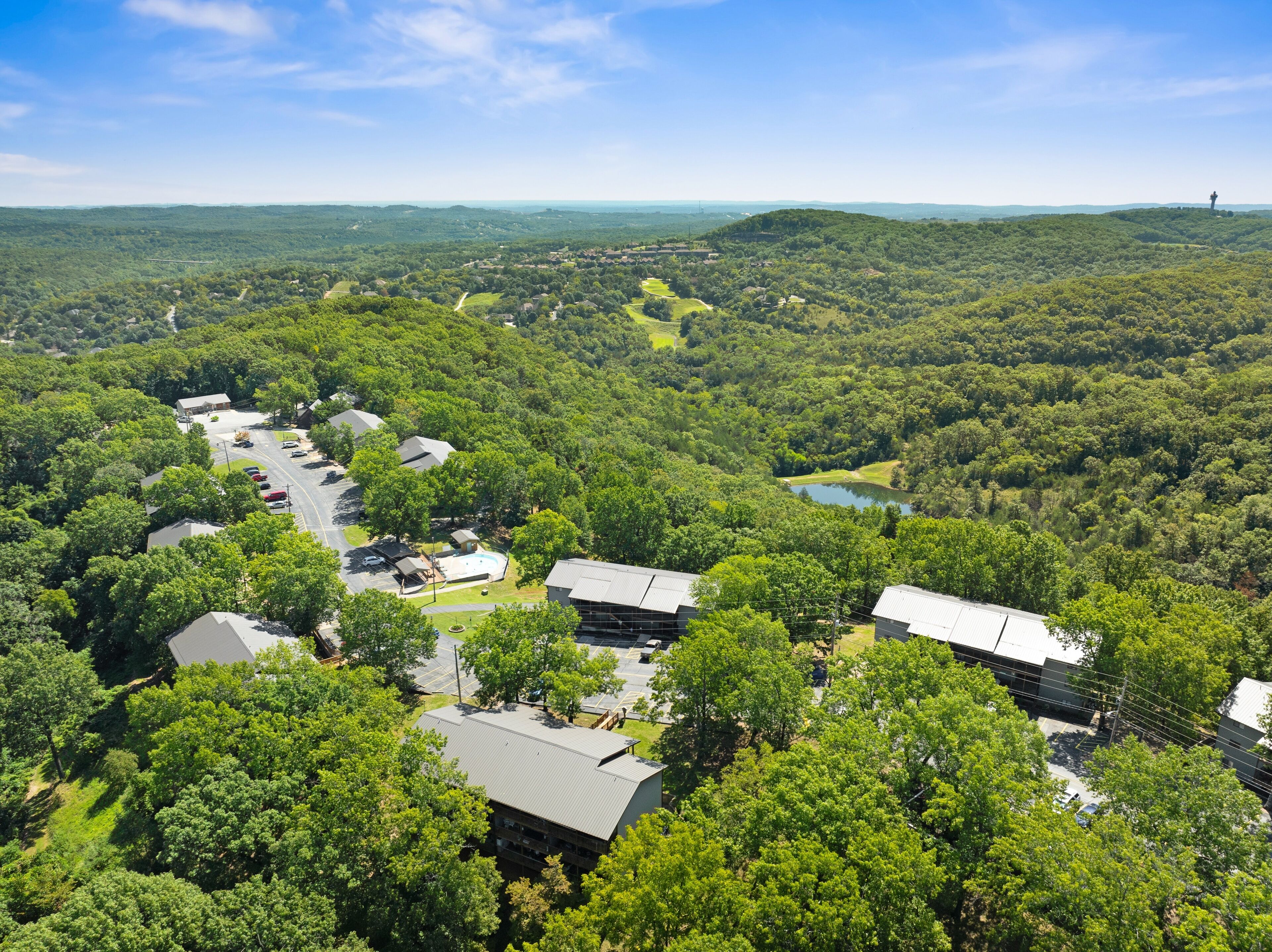An aerial view of a residential area with houses, a road, and a lake.