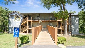 Un bâtiment doté d’une terrasse en bois menant à une entrée abritée, d’un panneau indiquant qu’il est accessible aux personnes en fauteuil roulant et d’un autre panneau indiquant qu’il est accessible aux fourgonnettes adaptées.