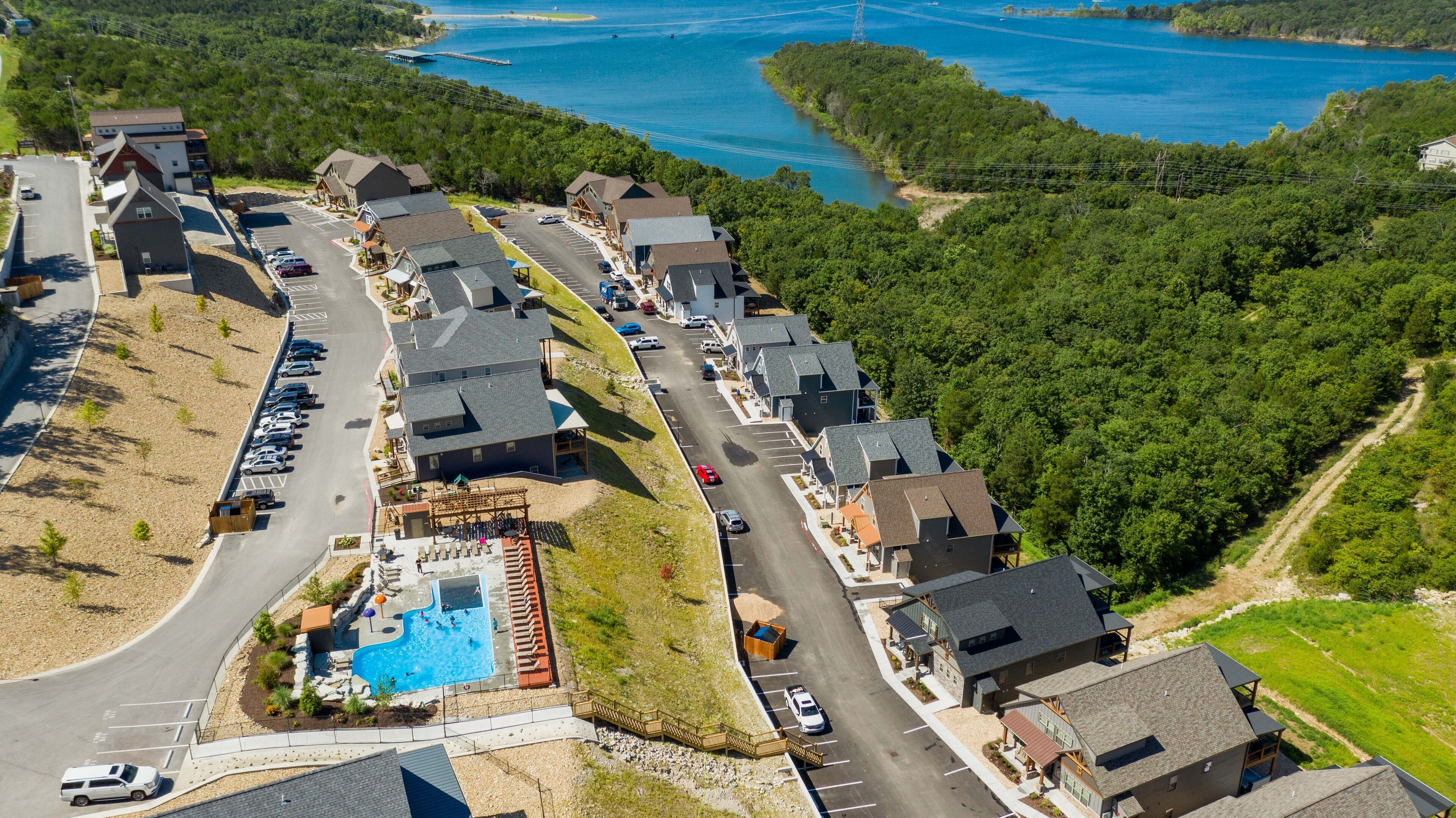 Un quartier résidentiel avec des maisons, une piscine et une route.