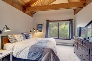 Cozy retreat with a large bed, dresser, and flat-screen TV.