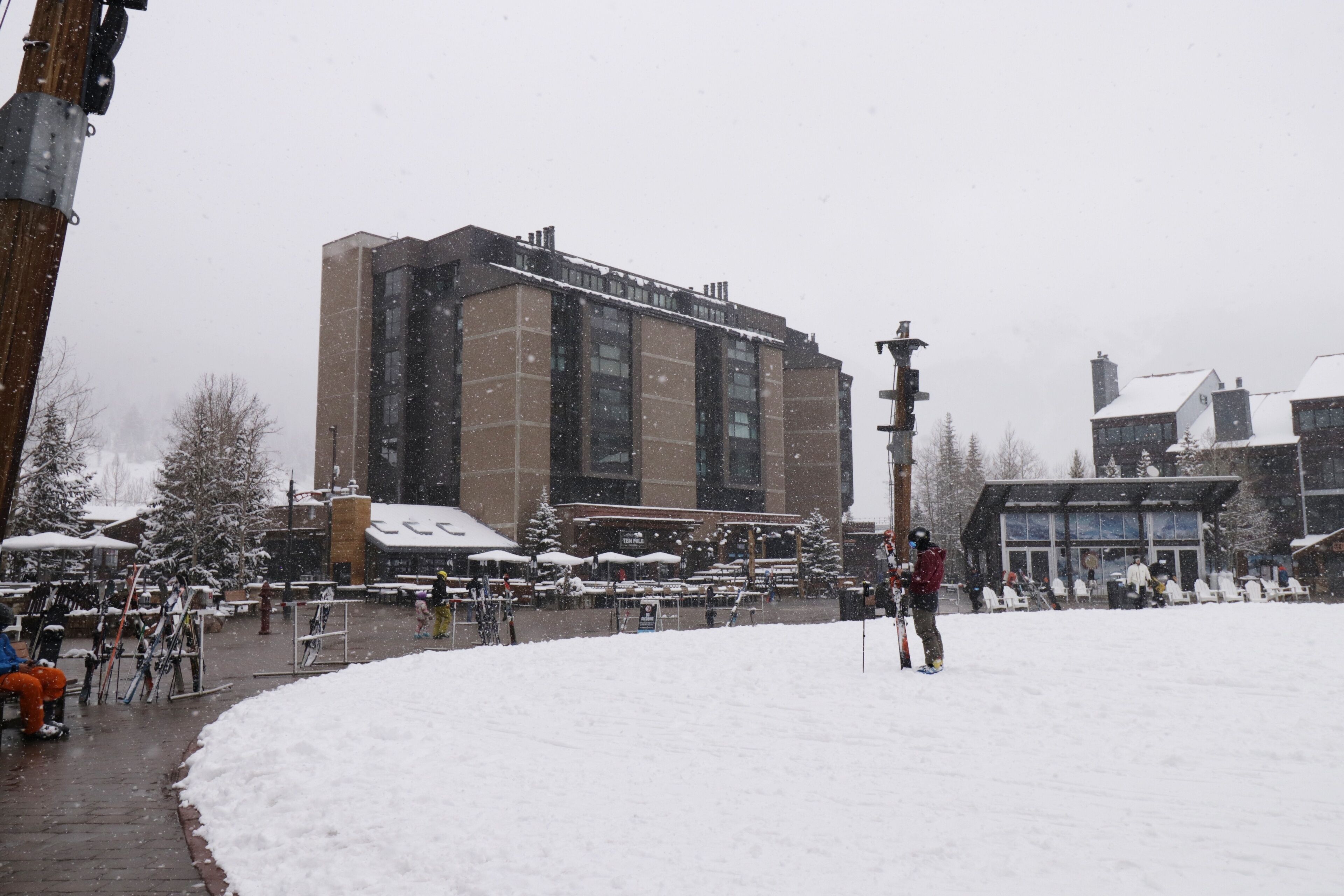 A snowy outdoor area with a building in the background.