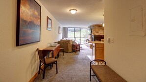 A spacious living room with a fireplace, a dining area, and a kitchen with wooden cabinets.