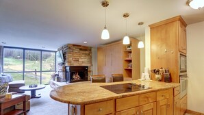 A modern kitchen with wooden cabinets, a large island, and pendant lighting.