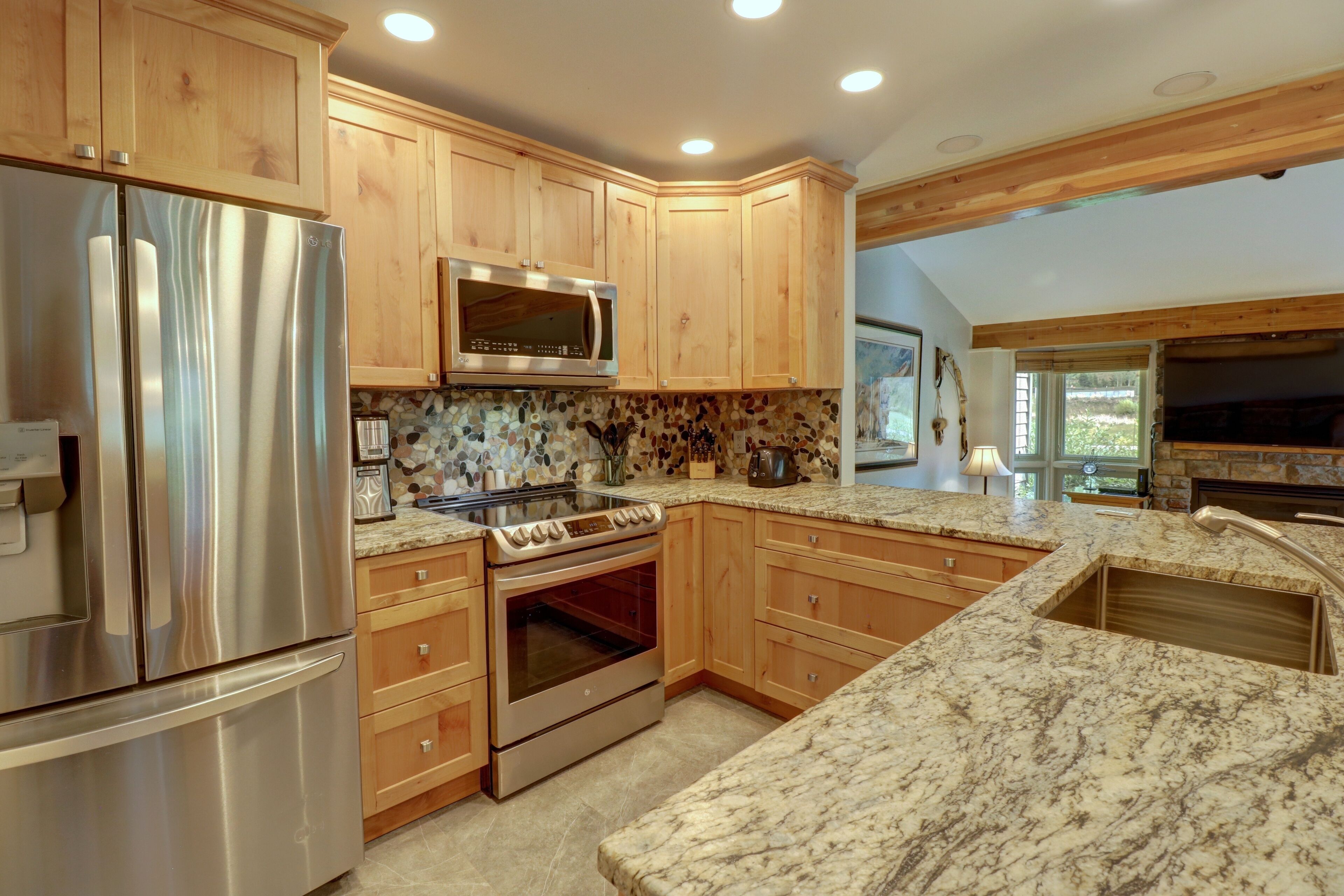 A kitchen with wooden cabinets, stainless steel appliances, and a granite countertop.