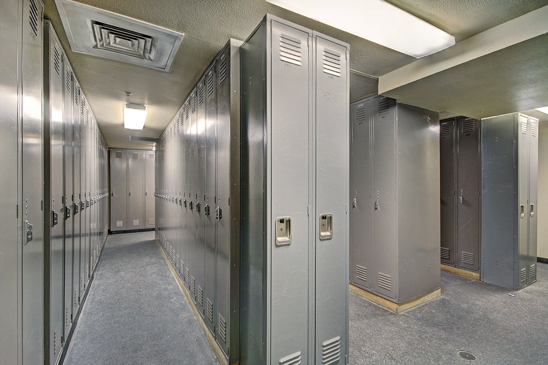 A hallway with lockers and a door at the end.