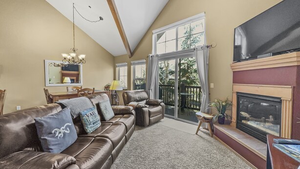 A spacious living room with a brown leather sofa, a fireplace, and a large TV. - B6 Tarn Landing 1br + Loft, 3ba 1 Bedroom Condo (Frisco)