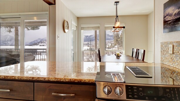 A kitchen with a large island, a view of mountains, and a dining area with chairs. - E101 Lake Cliffe 2 Bedroom Condo (Dillon)