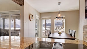 A modern kitchen with a large island, a dining area with a view, and a fireplace. - E101 Lake Cliffe 2 Bedroom Condo (Dillon)