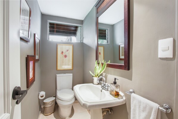 Un baño pequeño con inodoro, lavabo y espejo.