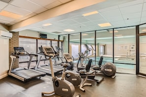 A gym with treadmills, stationary bikes, and an indoor pool.