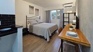 A compact bedroom with a bed, a small table, and a window. - Premium Suite No. 102 at the Metropolitan Hotel in Bauru, with magnificent breakfast (Jardim Estoril Bauru)