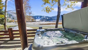A hot tub with a wooden deck and a view of a snowy mountain landscape. - 203 Chaparral Luxury At Deer Valley 2 Bedroom Condo (Park City)