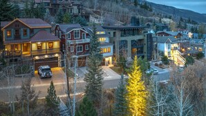 A residential area with houses, a driveway, and a parked SUV. - 521 Woodside Gem True Ski-in Ski-out On The Gold Coast 3 Bedroom Home (Park City)